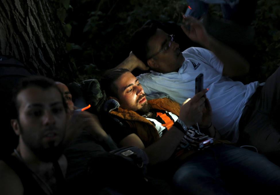A Syrian immigrant calls friends on his mobile after crossing the borderinto Macedonia, along with another 45 Syrian immigrants, near the Greek village of Idomeni in Kilkis prefecture, May 14, 2015. REUTERS/Yannis Behrakis