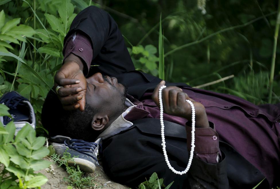 An immigrant from Mali rests at the Greek-Macedonian border before an attempt to flee to Macedonia May 13, 2015 village of Idomeni in Kilkis prefecture, May 13, 2015. REUTERS/Yannis Behrakis