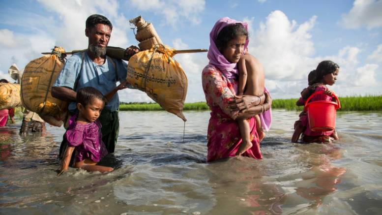 Mια οικογένεια Rohingya βαδίζει μέσα από το νερό για να διασχίσει το πέρασμα από τη Μυανμάρ στο Μπανγκλαντές. ©UNHCR_Roger Arnold